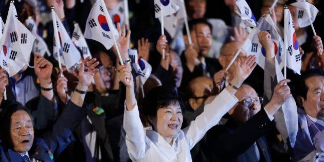 South Korean President Park Geun-hye, bottom center, gives three cheers for her country during a ceremony to celebrate Korean Liberation Day from Japanese colonial rule in 1945, at Seong Cultural Center in Seoul, South Korea, Monday, Aug. 15, 2016. (AP Photo/Ahn Young-joon, Pool)