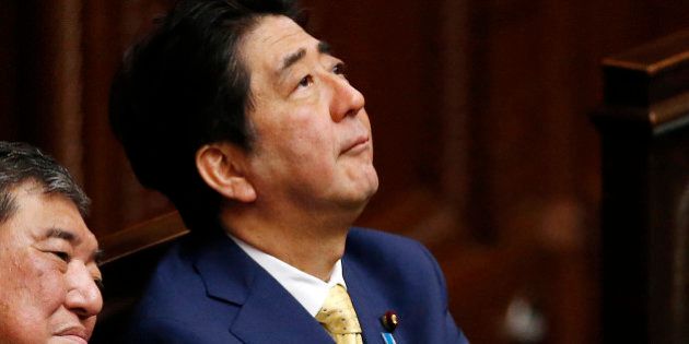 Japanese Prime Minister Shinzo Abe, looks up during a plenary session at the lower house in Tokyo, Thursday, July 16, 2015. Japan's lower house of parliament on Thursday approved legislation that would allow an expanded role for the nation's military in a vote boycotted by the opposition. Shigeru Ishiba, the minister for Vitalizing Local Economy in Japan is seen at left.(AP Photo/Shuji Kajiyama)