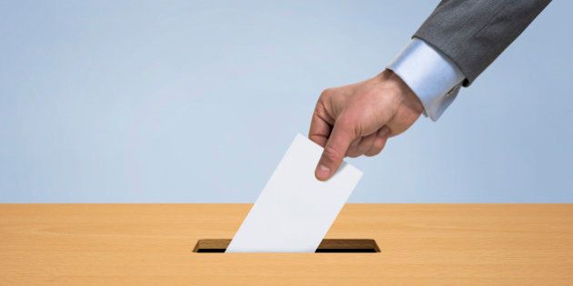 Male hand inserting a blank vote