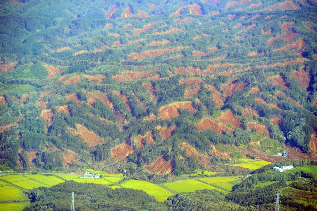 広範囲に発生した地滑りでむき出しになった山肌＝北海道厚真町上空