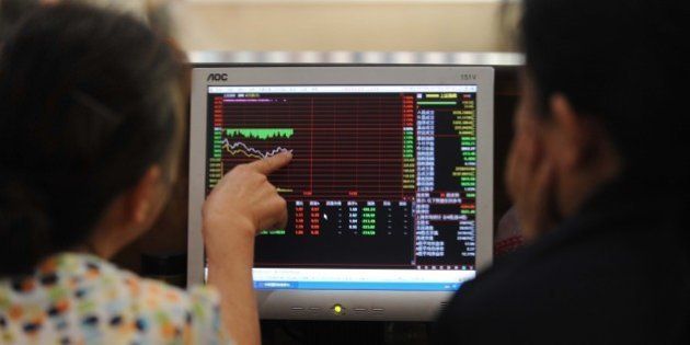 Investors talk to each other as they check stock prices at a securities firm in Wuhan, in central China's Hubei province on July 3, 2015. Shanghai shares on July 3 extended their plunges of recent weeks, ending the morning session down more than three percent in volatile trading as analysts said panic was setting in. CHINA OUT AFP PHOTO (Photo credit should read STR/AFP/Getty Images)