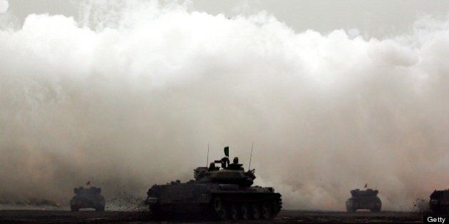 GOTENBA, JAPAN - AUGUST 23: Tanks fire shells during the annual Japan's Self Defense Forces live-firing exercise at the Higashi Fuji training facility on August 23, 2007 in Gotenba, Japan. The post-war constitution restricts Japan from having military forces sufficient to lead war. Self Defense Forces, created strictly to maintain peace and safety, operate with nearly 240,000 personnel. (Photo by Junko Kimura/Getty Images)