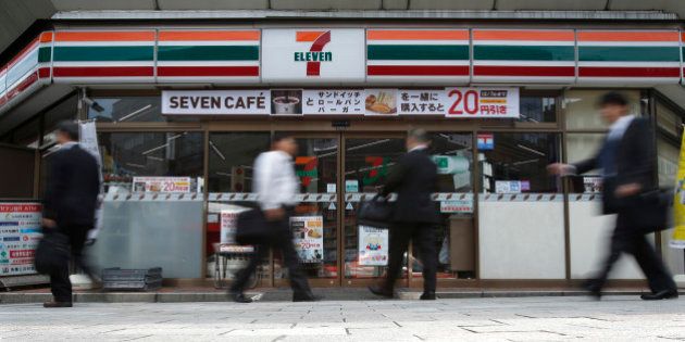 Pedestrians walk past a 7-Eleven convenience store, operated by Seven & I Holdings Co., in Tokyo, Japan, on Thursday, Oct. 3, 2013. Seven & I reported a 25 percent rise in first-half net income, in line with analysts' estimates. Photographer: Kiyoshi Ota/Bloomberg via Getty Images