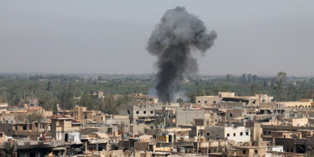 A photo taken on August 13, 2013 shows smoke billowing from buildings in Syria's eastern town of Deir Ezzor following an airstrike by government forces. Syrian opposition activists, including National Coalition members, have drawn up a transitional roadmap including a call for national reconciliation and justice for 'all of Syria's victims,' a statement said. AFP PHOTO / ABO SHUJA (Photo credit should read ABO SHUJA/AFP/Getty Images)