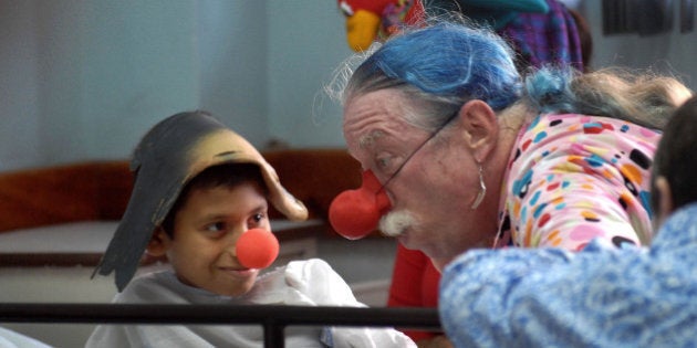 Dr. Hunter Patch Adams talks with a boy on a hospital bed at a public pediatric hospital in Panama City, Panama, Wednesday, Nov. 29, 2006. Adams is on tour in Panama visiting public clinics and giving lectures to medical students. (AP Photo/Tito Herrera)