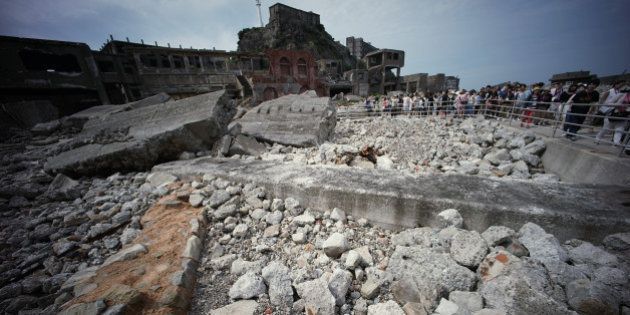 In this June 29, 2015 photo, forlorn buildings are seen at Hashima Island, commonly known as Gunkanjima, which means âbattleship island,â off Nagasaki, Nagasaki Prefecture, southern Japan. The island is one of 23 old industrial facilities seeking UNESCO's recognition as world heritage âSites of Japanâs Meiji Industrial Revolutionâ meant to illustrate Japan's rapid transformation from a feudal farming society into an industrial power at the end of the 19th century. UNESCOâs World Heritage Committee is expected to approve the proposal during a meeting being held in Bonn, Germany, through July 9. (AP Photo/Eugene Hoshiko)