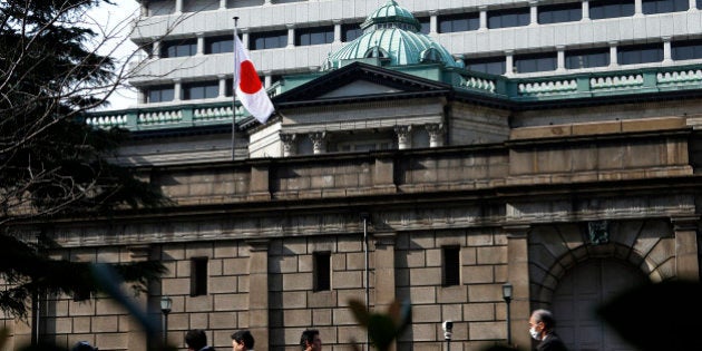 Pedestrians walk past the Bank of Japan headquarters in Tokyo, Japan, on Thursday, March 7, 2013. The Bank of Japan rejected a call for an immediate start to open-ended asset purchases in Governor Masaaki Shirakawa?s final meeting before a new leadership takes over at the central bank. Photographer: Kiyoshi Ota/Bloomberg via Getty Images