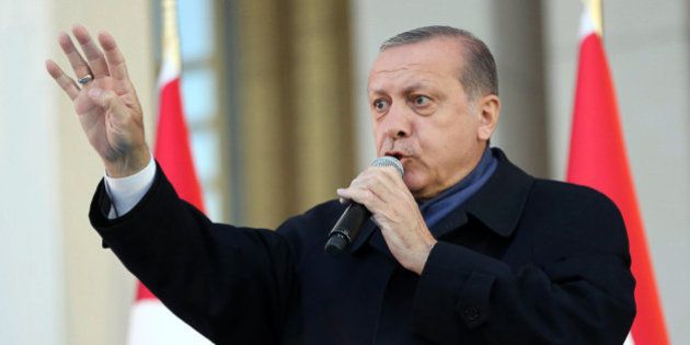 Turkish president Recep Tayyip Erdogan flashes a four finger sign called 'the rabia sign' as he delivers a speech to his supporters at the Presidential Palace in Ankara, April 17, 2017 following the results in a nationwide referendum that will determine Turkey's future destiny.Erdogan on April 17 said Turkey could hold a referendum on its long-stalled EU membership bid after Turks voted to approve expanding the president's powers in a plebiscite. Narrowly won by President Recep Tayyip Erdogan, the referendum asked voters to boost the powers of the Turkish head of state -- a move that rights watchdogs have said could fatally weaken democracy in the linchpin country. / AFP PHOTO / ADEM ALTAN (Photo credit should read ADEM ALTAN/AFP/Getty Images)