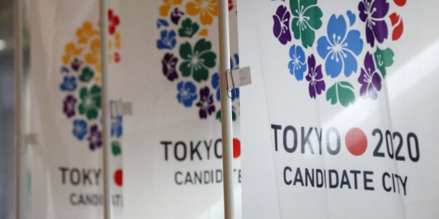 Flags promoting Japan's bid for the 2020 Olympics and Paralympic Games are displayed during a media tour in Tokyo, Japan, on Monday, July 29, 2013. Tokyo, the front-runner city to host the 2020 Olympics, is planning its biggest housing complex in 42 years to lodge athletes, a move that could benefit developers such as Shimizu Corp. and Mitsubishi Estate Co. Photographer: Tomohiro Ohsumi/Bloomberg via Getty Images