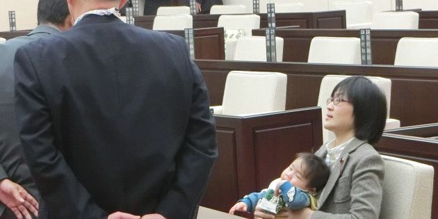 2017年11月、熊本市議会に生後7カ月の長男を抱いたまま出席し、議会事務局職員らによる退席要請を拒否する緒方夕佳市議（右）＝熊本市中央区