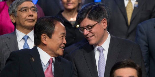 Jacob 'Jack' Lew, U.S. treasury secretary, right, talks to Taro Aso, Japan's finance minister, during the Group of 20 nations (G-20) finance ministers and central bank governors family photograph on the sidelines International Monetary Fund and World Bank Group Annual Meetings in Washington, D.C., U.S., on Friday, Oct. 11, 2013. Any measures by Asian policy makers to implement capital controls on outflows could backfire and officials should focus on easing existing restrictions on money entering their economies, the IMF said today. Photographer: Andrew Harrer/Bloomberg via Getty Images
