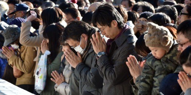 Japanese worshippers pray as they celebrate the New Year at Meiji shrine in Tokyo on January 1, 2015. Millions of Japanese visit shrines and temples to pray for the well-being of their families at the New Year. AFP PHOTO / KAZUHIRO NOGI (Photo credit should read KAZUHIRO NOGI/AFP/Getty Images)