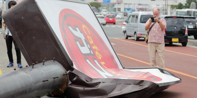 台風24号の強風で倒れたファミリーレストランの看板＝30日、沖縄県浦添市