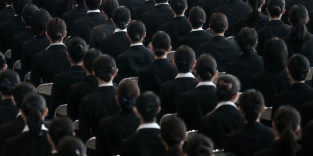 TOKYO, JAPAN - APRIL 01: New recruits listen to speeches during the welcome ceremony for new employees of All Nippon Airways Holdings (ANA) at ANA hanger on April 1, 2015 in Tokyo, Japan. 1,189 new employees were welcomed by ANA President and CEO Shinya Katanozaka. As the majority of Japanese start their career on April 1st after graduating from schools in February or March, it is a custom for large Japanese corporations to hold mass welcoming ceremonies for their new employees. (Photo by Chris McGrath/Getty Images)