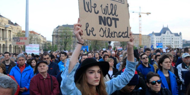 A woman holds a placard as she protests against the bill that would undermine Central European University, a liberal graduate school of social sciences founded by U.S. financier George Soros in Budapest, Hungary, April 9, 2017. REUTERS/Bernadett Szabo