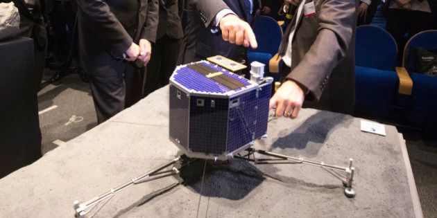 From left, French Education Minister Najat Vallaud-Belkacem, French National Centre for Space Studies (CNES) president Jean-Yves Le Gall, 2nd left, French President Francois Hollande, center, with French astrophysicist Francis Rocard look at a model of Rosetta lander Philae as they visit the Cite des Sciences at La Villette during a broadcast of the Rosetta mission as it orbits around comet 67/P Churyumov-Gersimenko in Paris, Wednesday, Nov. 12, 2014. Hundreds of millions of miles from Earth, a European spacecraft made history Wednesday by successfully landing on the icy, dusty surface of a speeding comet â an audacious first designed to answer big questions about the universe. (AP Photo/Jacques Brinon, Pool)