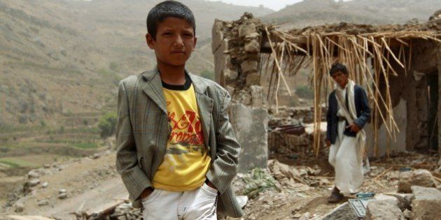 A Yemeni boy stands in front of a damaged house in the village of Bani Matar, 70 kilometers (43 miles) West of Sanaa, on April 4, 2015, a day after it was reportedly hit by an airstrike by the Saudi-led coalition against Shiite Huthi rebel positions. A Saudi-led coalition pounded rebels in southern Yemen and dropped more arms to loyalist fighters as the UN Security Council prepared to discuss calls for 'humanitarian pauses' in the air war. AFP PHOTO / MOHAMMED HUWAIS (Photo credit should read MOHAMMED HUWAIS/AFP/Getty Images)