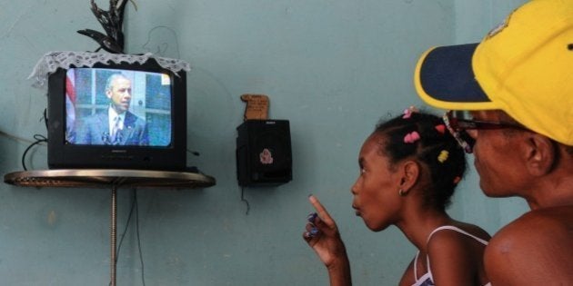 Cubans watch US President Barack Obama talking on TV about the reestablishment of full diplomatic ties with Cuba, in Havana on July 1, 2015. President Barack Obama announced that the United States and Cuba will re-establish full diplomatic relations, severed 54 years ago in the angry heat of the Cold War. The US president and Cuban state television simultaneously announced the landmark agreement, aimed at easing decades of enmity across the narrow Straits of Florida. Under the deal, embassies in Washington and Havana will be reopened as soon as July 20, in what Obama described as a 'historic step forward,' and a 'new chapter' in US relations with Latin America. AFP PHOTO / YAMIL LAGE (Photo credit should read YAMIL LAGE/AFP/Getty Images)