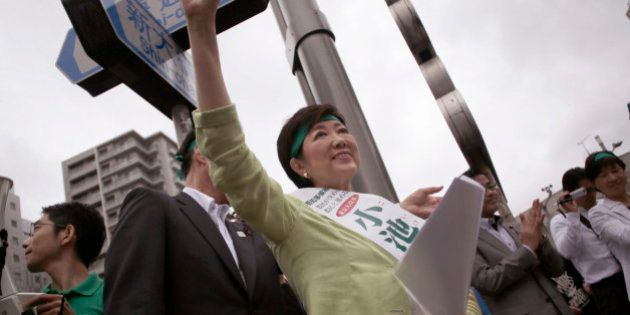 In this Friday, July 22, 2016 photo, former defense minister Yuriko Koike waves at passersby during her campaign rally for the Tokyo gubernatorial election in Tokyo. Japanâs capital with a population of more than 13 million people is voting Sunday, July 31, for its leader after two predecessors resigned over money scandals as Tokyo prepares to host the 2020 Olympics, and hopes to lead the nation in an economic turnaround. (AP Photo/Eugene Hoshiko)