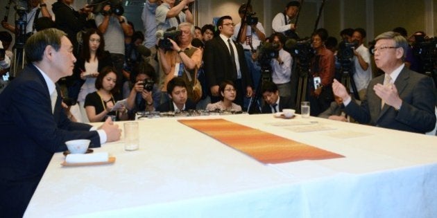 Japan's Chief Cabinet Secretary Yoshihide Suga (L) meets with Okinawa Governor Takeshi Onaga (R) in Naha, Okinawa prefecture on April 5, 2015. Japanese Prime Minister Shinzo Abe's right-hand man on April 5 urged the governor of Okinawa to concede in a lingering row over the construction of a US air base ahead of Abe's tour to Washington later this month. JAPAN OUT AFP PHOTO / JIJI PRESS (Photo credit should read STR/AFP/Getty Images)