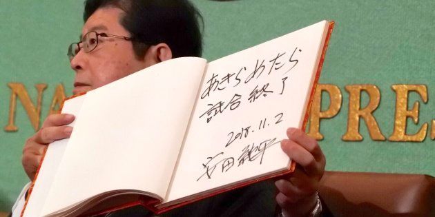 安田純平さんが記帳したサインを紹介する司会者。