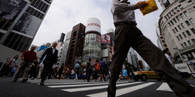 Pedestrians cross a street in the Ginza district of Tokyo, Japan, on Monday, Sept. 30, 2013. Large Japanese manufacturers confidence jumped more than economists forecast, bolstering the case for Prime Minister Shinzo Abe to press ahead with an increase in the nations sales tax. Photographer: Akio Kon/Bloomberg via Getty Images