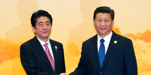 Japan's Prime Minister Shinzo Abe shakes hands with Chinese President Xi Jinping during a welcome ceremony for the Asia-Pacific Economic Cooperation (APEC) Economic Leaders Meeting held at the International Convention Center in Yanqi Lake, Beijing, on Tuesday, Nov 11, 2014. (AP Photo/Ng Han Guan)