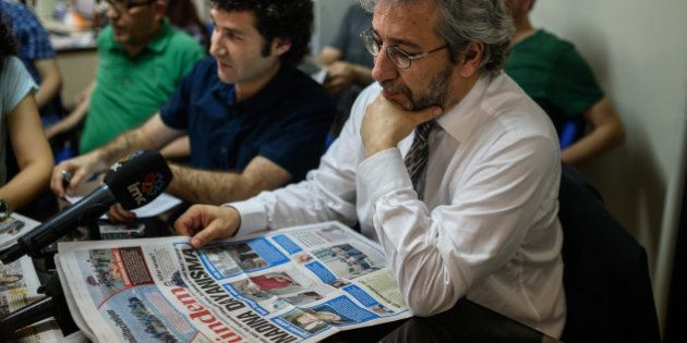 Cumhuriyet Daily newspaper Editor-in-chief Can Dundar (R), takes part in a news meeting at the Pro Kurdish Ozgur Gundem newspaper in Istanbul on June 21, 2016, a day after RSF representative Erol Onderoglu, journalist Ahmet Nesin and rights activist and academic Sebnem Korur Fincanci were charged for taking part in a campaign of solidarity with a pro-Kurdish newspaper in May.. Turkey stepped up its crackdown on the media on June 20, detaining and charging the local representative of international rights group Reporters Without Borders (RSF) and two intellectuals for 'terrorist propaganda'. RSF representative Erol Onderoglu, journalist Ahmet Nesin and rights activist and academic Sebnem Korur Fincanci were charged for taking part in a campaign of solidarity with a pro-Kurdish newspaper in May. / AFP / OZAN KOSE (Photo credit should read OZAN KOSE/AFP/Getty Images)