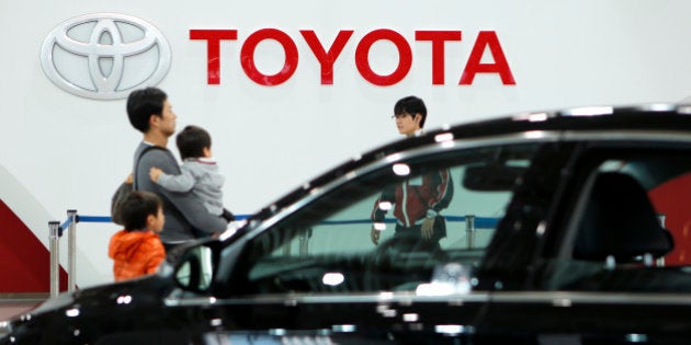 Visitors walk past a Toyota Motor Corp. Avalon vehicle, front, at the company's showroom in Tokyo, Japan,...