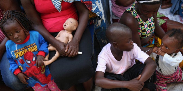 MONROVIA, LIBERIA - OCTOBER 17: Family members gather outside a home in the West Point neighborhood where a man's dead body awaited the arrival of an Ebola burial team to take him for cremation on October 17, 2014 in Monrovia, Liberia. The World Health Organization says that more than 4,500 people have died due to the Ebola epidemic in West Africa with a 70 percent mortality rate for those infected with the virus. (Photo by John Moore/Getty Images)