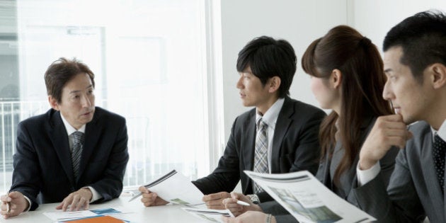 BUSINESS SCENE Four persons in a meeting