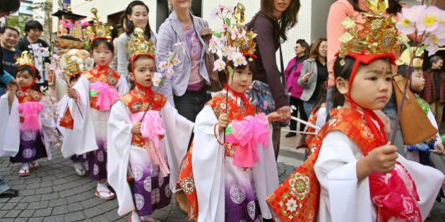 Tokyo, JAPAN: Girls wearing Japanese traditional costumes attend a parade on a street of Tokyo's Azabu-Juban, 09 April 2006, as a Buddhist event 'flower festival' to celebrate the birthday of the Buddha 08 April. Some 100 children attended the event. AFP PHOTO / Kazuhiro NOGI (Photo credit should read KAZUHIRO NOGI/AFP/Getty Images)