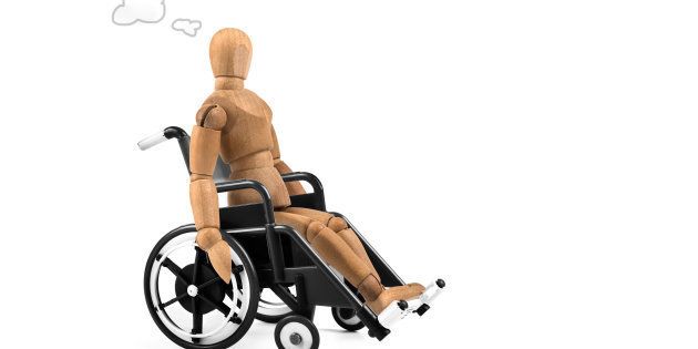 Disabled wooden mannequin in wheelchair thinking about cause, problems or future