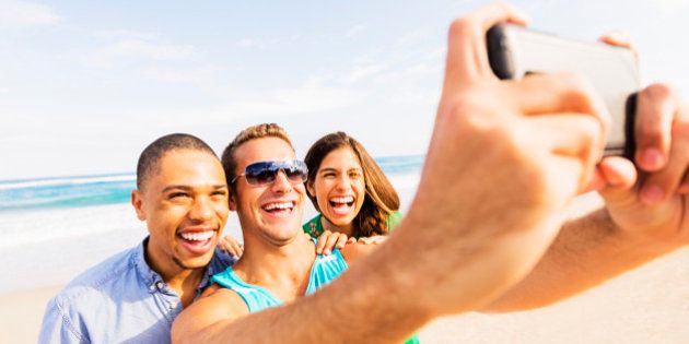 USA, Florida, Jupiter, Young people taking selfie on beach