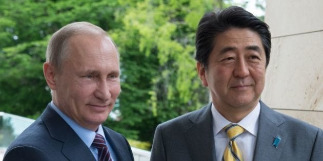 Russian President Vladimir Putin (L) welcomes Japanese Prime Minister Shinzo Abe during a meeting at the Bocharov Ruchei state residence in Sochi on May 6, 2016. / AFP / SPUTNIK / Sergei Guneev (Photo credit should read SERGEI GUNEEV/AFP/Getty Images)