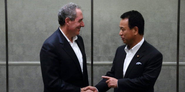 Michael Froman, U.S. trade representative, left, shakes hands with Akira Amari, Japan's minister of state...