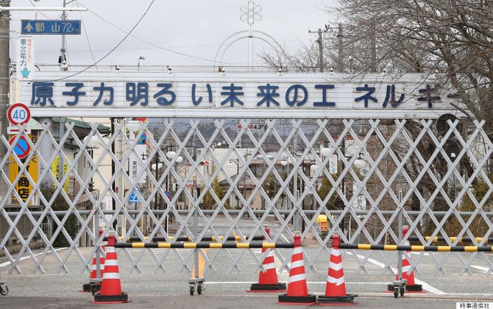 福島県双葉町の入り口に立つ看板。原子力発電所の推進を呼びかける標語「原子力明るい未来のエネルギー」と書かれている＝2015年2月17日、福島県双葉町