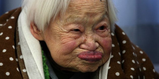 OSAKA, JAPAN - MARCH 05: Misao Okawa, who is recognised by Guinness World Records as the world's oldest woman, reacts during her 115th birthday celebrations at Kurenai Nursing Home on March 5, 2013 in Osaka, Japan. Misao Okawa, was born in Tenma, Osaka, on March 5, 1898. A descendent of Kimono merchants, she married in 1919 and had three children, of which a daughter and a son are still alive, and four grandchildren and six great-grandchildren. (Photo by Buddhika Weerasinghe/Getty Images)