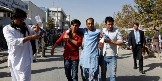 Men help an injured man outside a hospital after a suicide attack in Kabul, Afghanistan July 23, 2016. REUTERS/Mohammad Ismail