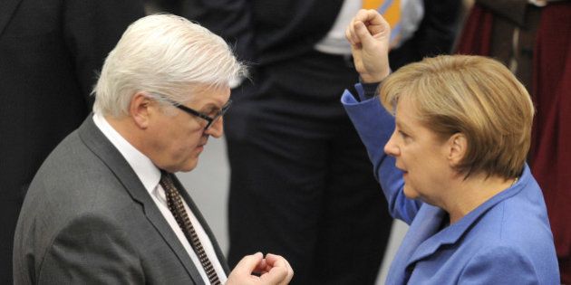 German Chancellor Angela Merkel speaks to Frank-Walter Steinmeier, leader of the Social Democratic Party's (SPD) parliamentary group, before addressing the Bundestag lower house of parliament in Berlin March 25, 2010, ahead of a crunch EU summit in Brussels. Merkel stuck to her hardline position on Greece ahead of the EU summit starting 26 March, saying she refused to violate 'the trust' of the German people in the euro. AFP PHOTO / JOHN MACDOUGALL (Photo credit should read JOHN MACDOUGALL/AFP/Getty Images)