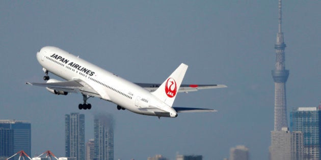 A Japan Airlines Co. (JAL) aircraft takes off from Haneda Airport while the Tokyo Sky Tree, right, stands...