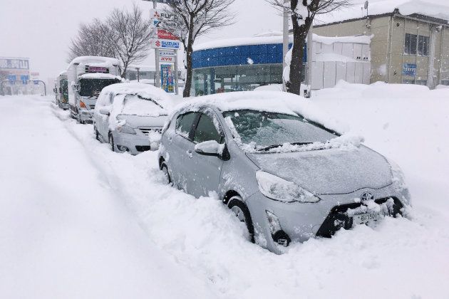 国道8号で立ち往生し、雪に埋もれた乗用車など＝2018年2月7日、福井市