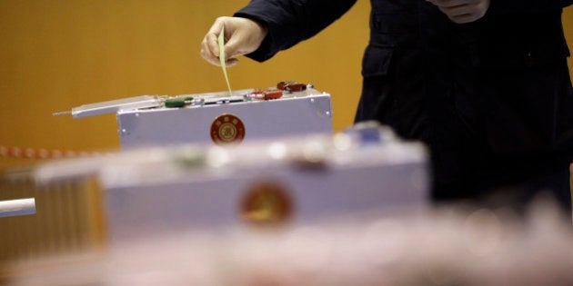 A man casts his vote in Japan's parliamentary elections at a polling station in Tokyo, Sunday, Dec. 14, 2014. Japanese voters headed to the polls Sunday in a parliamentary election that is expected to reaffirm the ruling Liberal Democratic Party's majority, though many analysts were predicting a record low turnout. (AP Photo/Eugene Hoshiko)