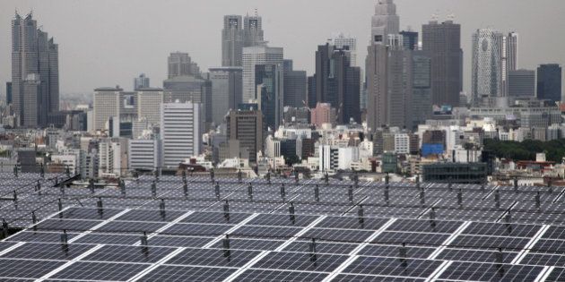 The Shinjuku district skyline rises behind solar panels at the solar power station on the rooftop of the Itochu Corp. headquarters in Tokyo, Japan, on Thursday, June 9, 2011. Japanese prime minister Naoto Kan pledged to generate 20 percent of the nation's electricity through renewable forms of energy by the 2020s as the nation rewrites its power blueprint in the aftermath of the world's worst nuclear disaster since Chernobyl. Photographer: Tomohiro Ohsumi/Bloomberg via Getty Images