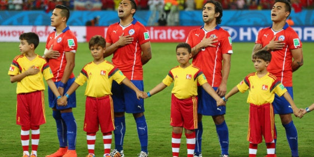 CUIABA, BRAZIL - JUNE 13: Chile line up and sing the National Anthem before the 2014 FIFA World Cup Brazil Group B match between Chile and Australia at Arena Pantanal on June 13, 2014 in Cuiaba, Brazil. (Photo by Clive Brunskill/Getty Images)