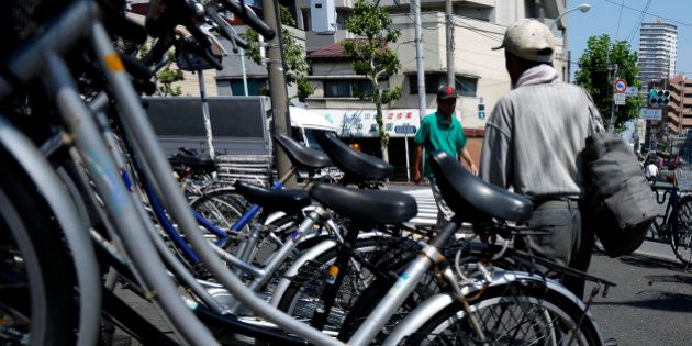 Elderly men walk past bicycles parked outside a store, unseen, in Tokyo, Japan, on Monday, July 8, 2013. The number of Japanese seniors living alone will rise 54 percent to 7.17 million in 2030 from 4.66 million in 2010, according to the National Institute of Population and Social Security Research, set up by the Ministry of Health, Labour and Welfare. To manage the costs stemming from the aging society, the government aims to push back the pension age to 65 from 60 in stages through 2025. Photographer: Kiyoshi Ota/Bloomberg via Getty Images