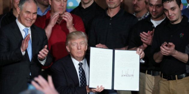 U.S. President Donald Trump holds up an executive order on