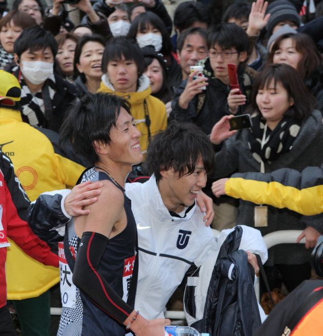 1位でゴールし笑顔を見せる東洋大アンカーの大津顕杜（手前左）。東洋大は2年ぶり4度目の総合優勝を果たした＝2014年1月3日、東京・大手町