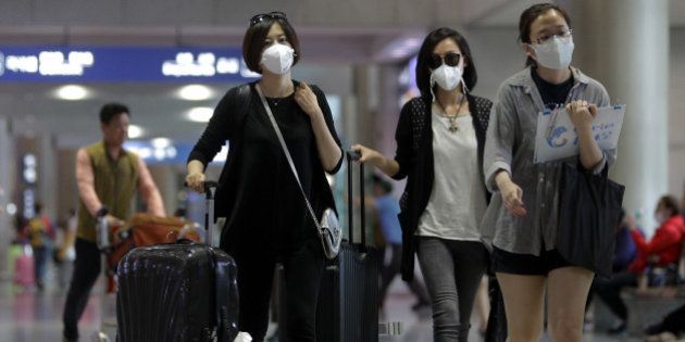 INCHEON, SOUTH KOREA - JUNE 06: Tourists wear masks as a precaution against the MERS virus at the Incheon International Airport on June 6, 2015 in Incheon, South Korea. Four deaths from Middle East Respiratory Syndrome (MERS) have been confirmed on June 5, 2015, and the number of confirmed local patients have risen to fifty as of June 6, 2015. (Photo by Chung Sung-Jun/Getty Images)