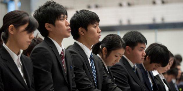 University students take notes as they attend a job fair hosted by Recruit Co. at Makuhari Messe in Chiba City, Japan, on Sunday, Dec. 11, 2011. Japan's economy grew less than the government's initial estimate last quarter as companies reduced investment on concern overseas demand was stalling. Photographer: Akio Kon/Bloomberg via Getty Images